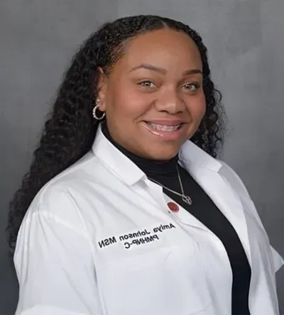 Herzing MSN-PMHNP graduate in lab coat